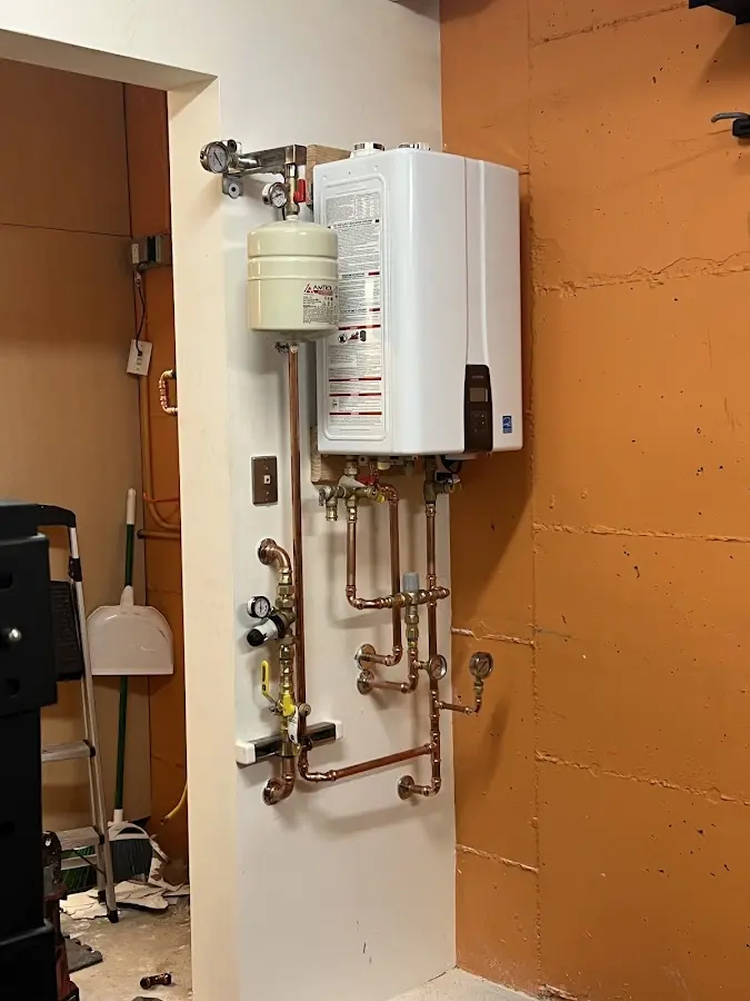 Plumbing technician inspecting water heater connections in Sky Lake